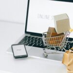 Mini shopping cart on laptop symbolizing online shopping and e-commerce transactions.